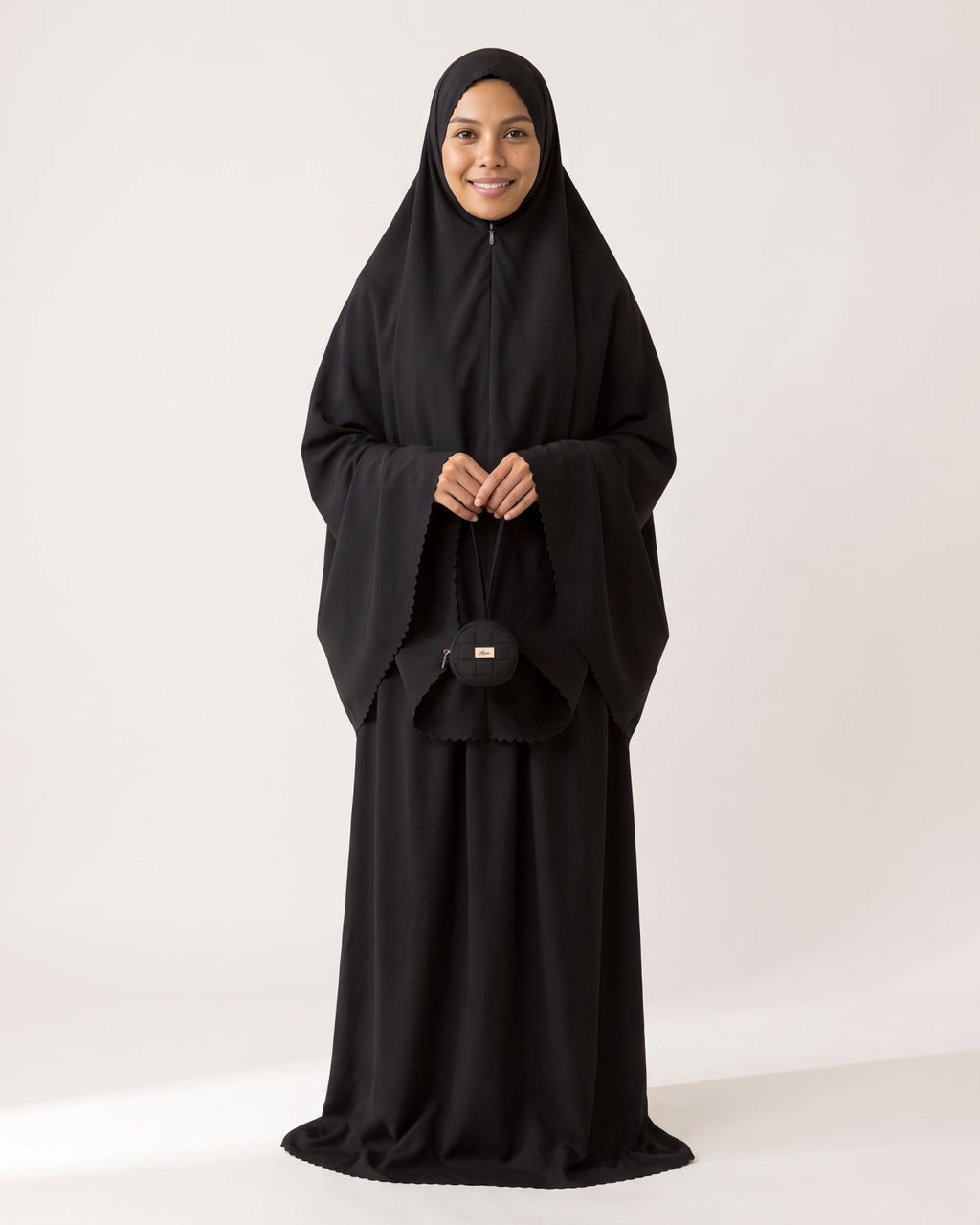 Pocket Prayer Outfit in Layl, black, holding the matching pouch